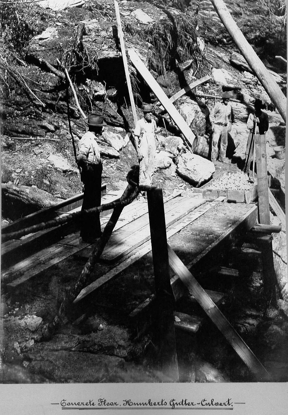 Men standing on concrete at culvert